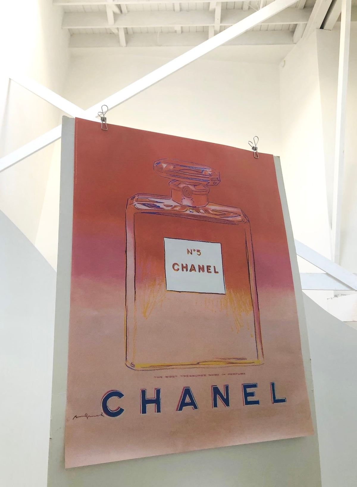 Angled side view of the 1997 Andy Warhol Italian Chanel pink poster on matte paper
